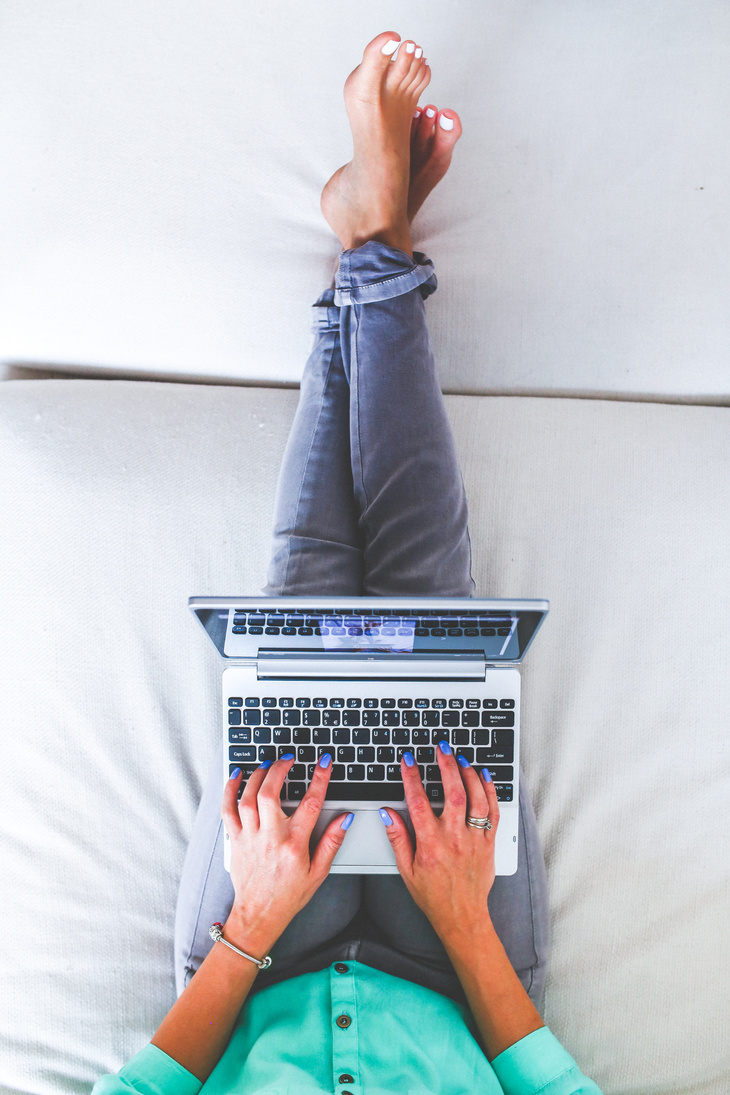 Woman Using Laptop in Bed